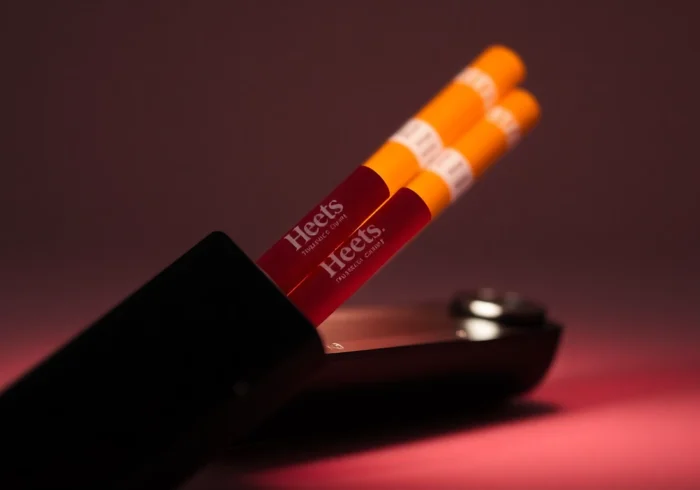 Sleek IQOS device with colorful Heets sigara sticks, showcasing modern heatstick design and tobacco texture for enhanced user appeal.